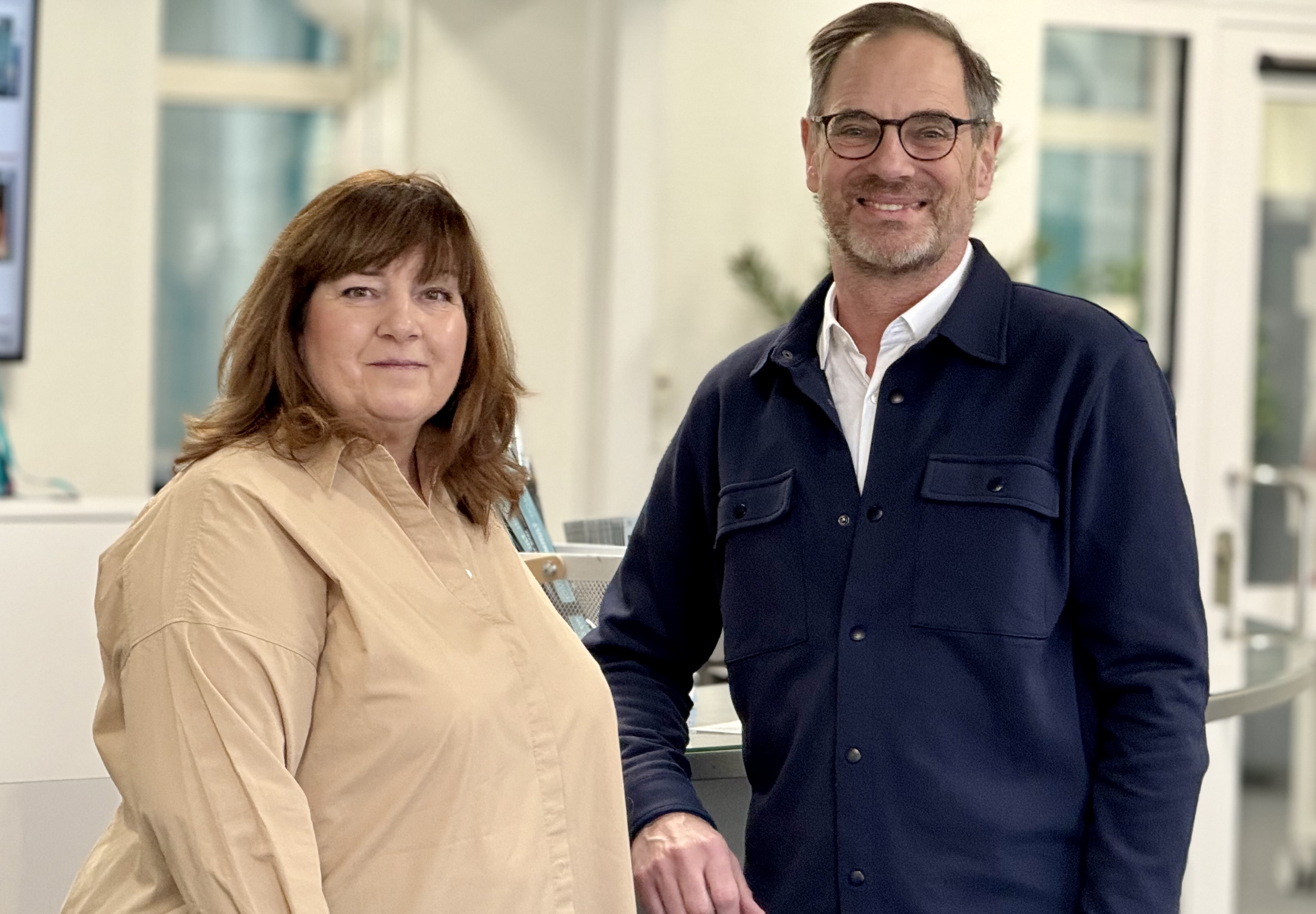 En kvinna och en man som poserar bredvid varandra