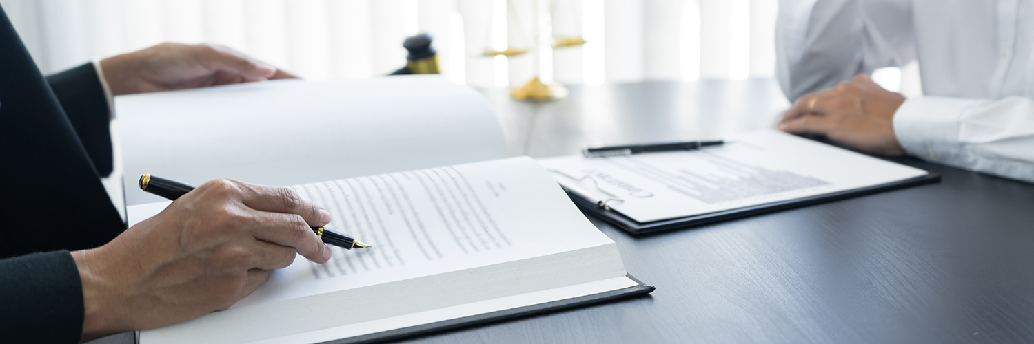 Två dokument med text på vitt papper där två personer sitter mitt emot varandra.